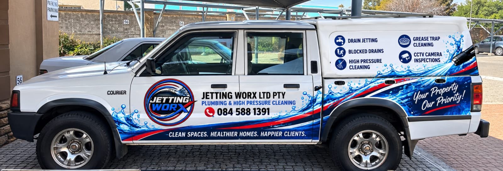 White Jetting Worx company vehicle with the official red and blue branding and phone number