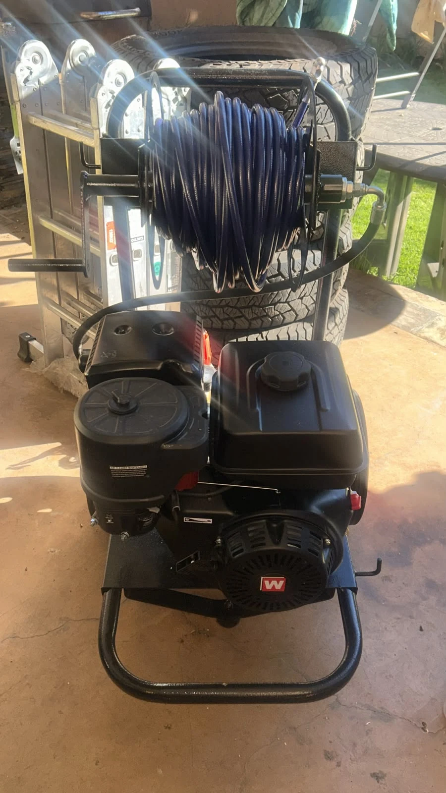Portable engine-powered pressure-cleaning equipment with a coiled hose reel